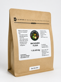 A 1 lb bag of Econ Nut's Macadamia Flour in a brown kraft paper stand-up pouch with a white label, photographed on a clean white background