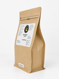 A kraft paper stand-up pouch of macadamia flour with a white label on the front, photographed on a clean white background