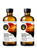 Two 16.9 fl oz bottles of Elgon Nuts pure cold pressed macadamia nut oil in amber glass packaging.